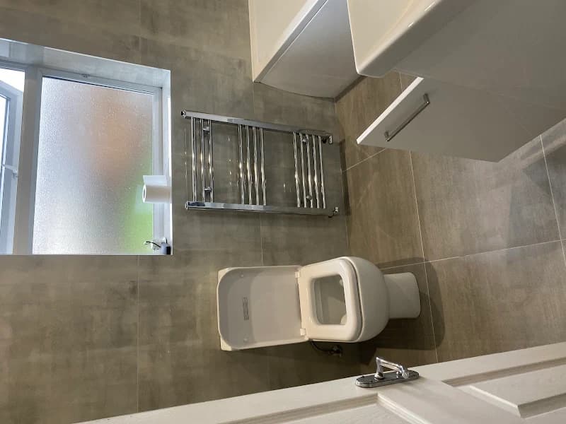 Modern bathroom with towel radiator and grey tiles - Bathroom renovation Wallington
